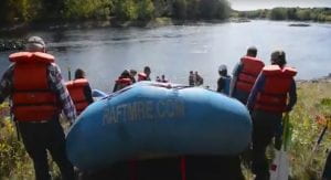Photo of a raft launch by faculty and students for a field trip on the Penobscot River in Old Town, Maine.